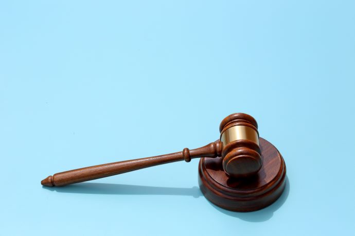 Brown gavel against a blue background