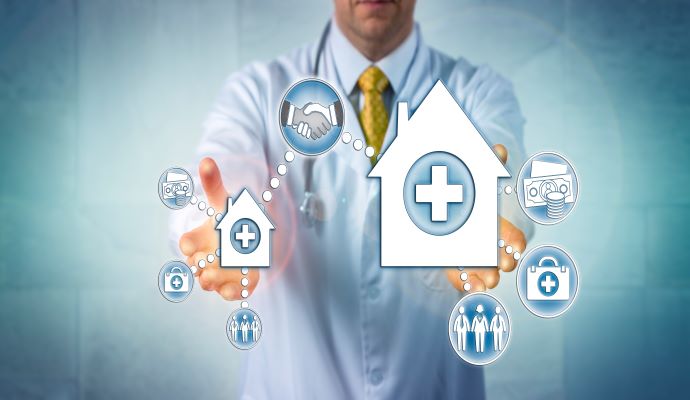 Man with white coat holding houses with medical cross symbols representing hybrid in-person and virtual care models