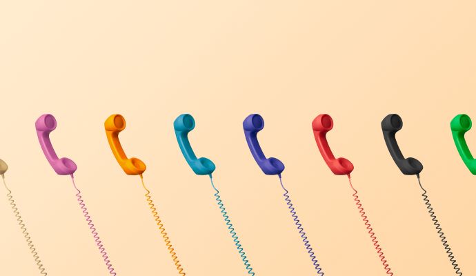 Multiple multicolored telephones with wires anchoring them off-screen. 