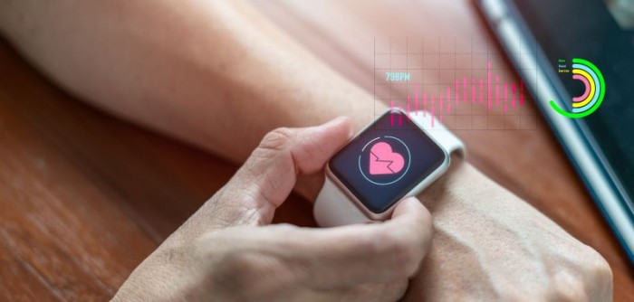 Arm with smartwatch on wrist with heart on it representing wearable-enabled cardiac care