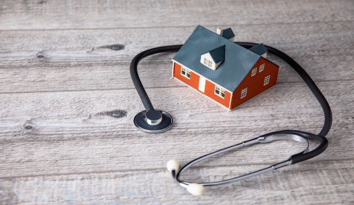 House on wooden floor with stethoscope around it