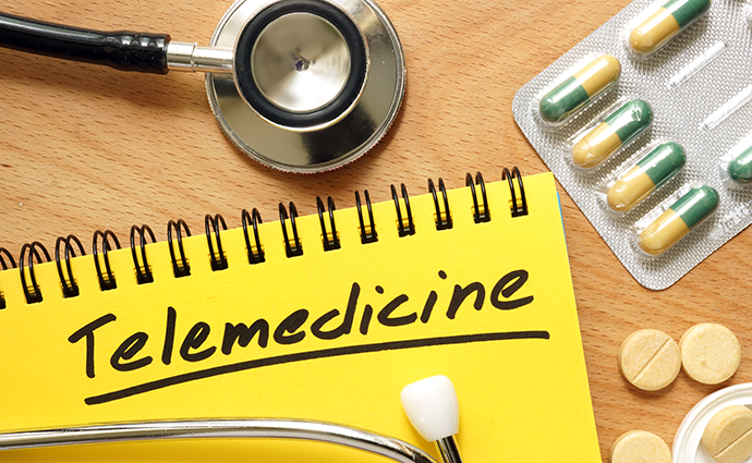 Notepad that says telemedicine with stethoscope and medications nearby